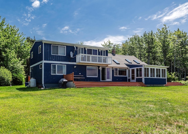 back of house featuring a sunroom and a lawn