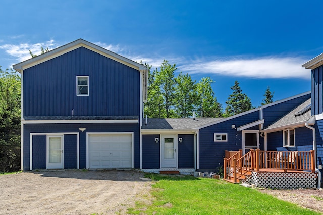 view of front of property with a garage, a front yard, and a wooden deck