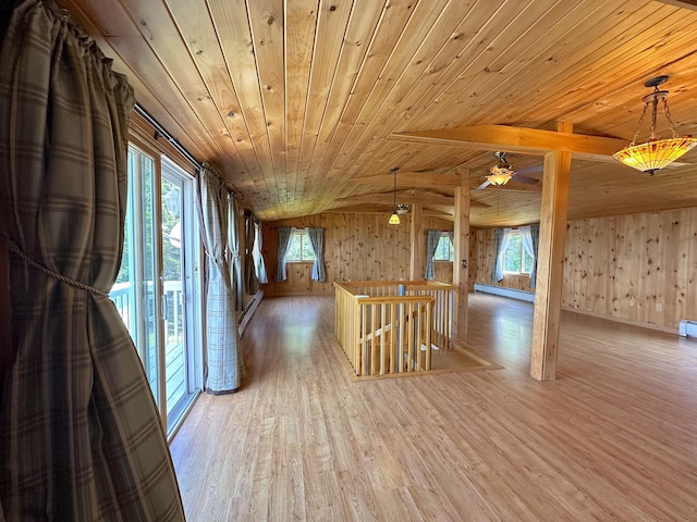 interior space with a baseboard heating unit, a healthy amount of sunlight, light hardwood / wood-style floors, lofted ceiling with beams, and wooden ceiling