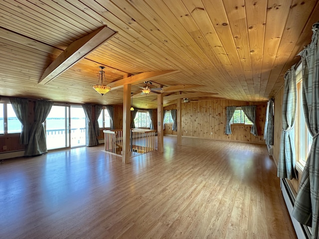 interior space featuring hardwood / wood-style floors, wood ceiling, a baseboard heating unit, wood walls, and ceiling fan