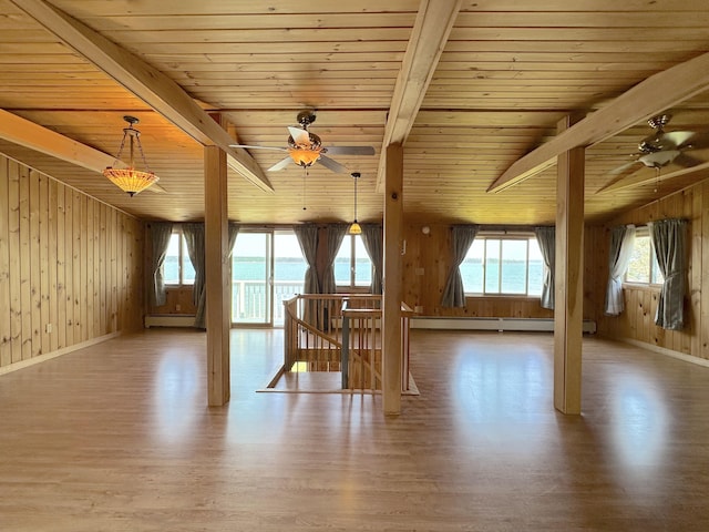 additional living space with ceiling fan, a baseboard heating unit, beam ceiling, and a water view