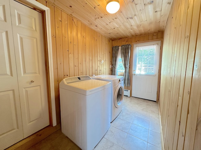 washroom featuring light tile patterned floors, wooden ceiling, washing machine and clothes dryer, and wooden walls