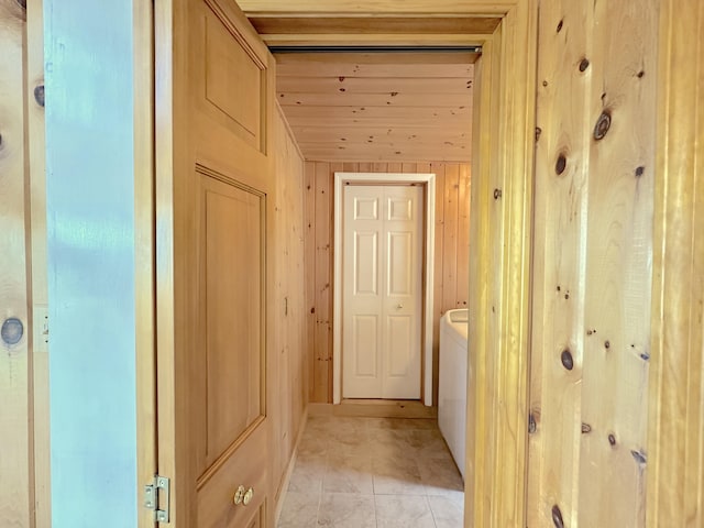 hallway featuring light tile patterned flooring and wooden walls