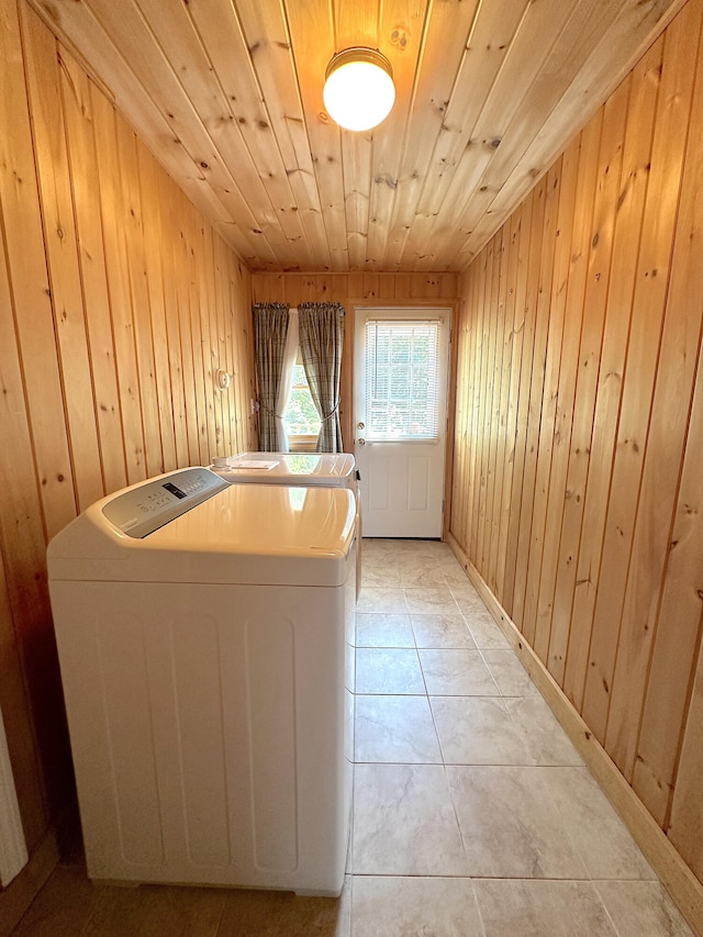 laundry area with washer and dryer, light tile patterned floors, wood walls, and wood ceiling