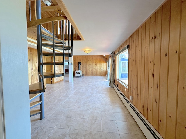 hall with light tile patterned flooring, wood walls, and a baseboard radiator