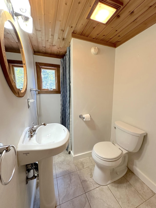 bathroom with wooden ceiling, toilet, ornamental molding, and tile patterned flooring