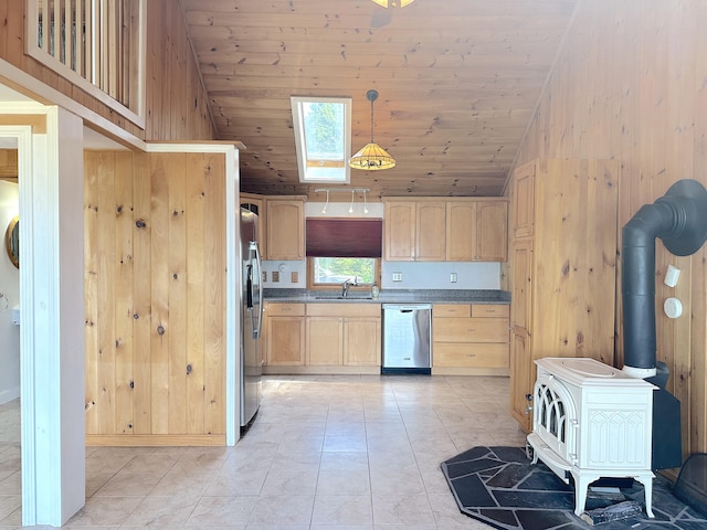 kitchen featuring a wood stove, appliances with stainless steel finishes, and wooden walls