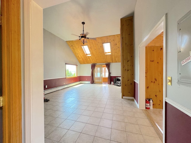 bonus room featuring a baseboard heating unit, ceiling fan, light tile patterned floors, and vaulted ceiling