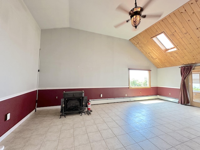 bonus room with light tile patterned floors, ceiling fan, wooden ceiling, a wood stove, and vaulted ceiling with skylight