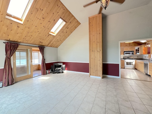 bonus room featuring light tile patterned floors, a skylight, wood ceiling, ceiling fan, and high vaulted ceiling