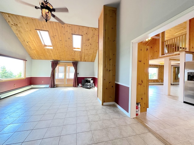 bonus room featuring a skylight, a baseboard heating unit, ceiling fan, light tile patterned flooring, and high vaulted ceiling