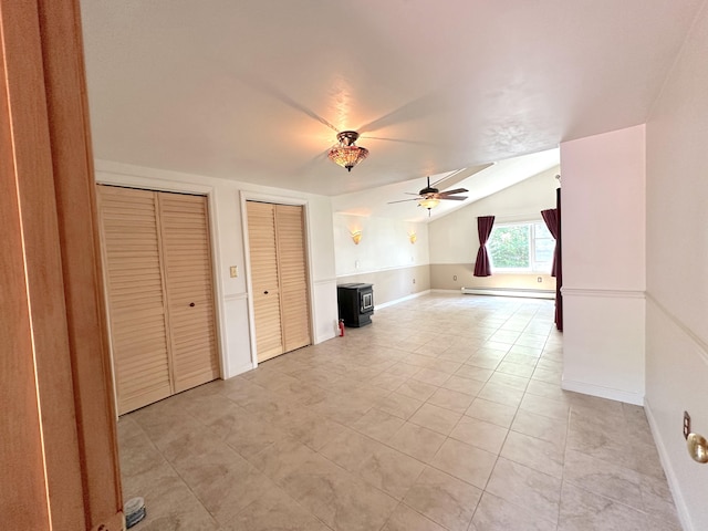 unfurnished living room with baseboard heating, lofted ceiling, and ceiling fan