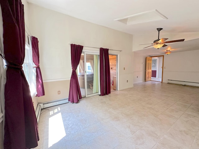 spare room featuring ceiling fan, a wealth of natural light, a baseboard heating unit, and vaulted ceiling