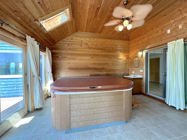 bathroom with wooden ceiling, vanity, wood walls, and a healthy amount of sunlight