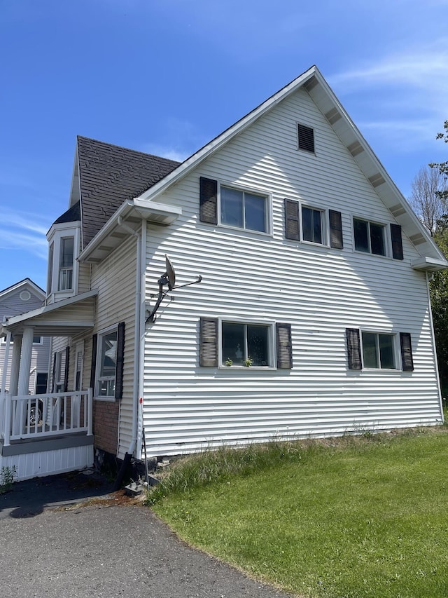 view of property exterior with a yard and covered porch