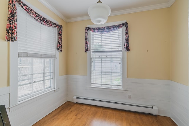 spare room featuring light wood-type flooring, crown molding, and a baseboard radiator