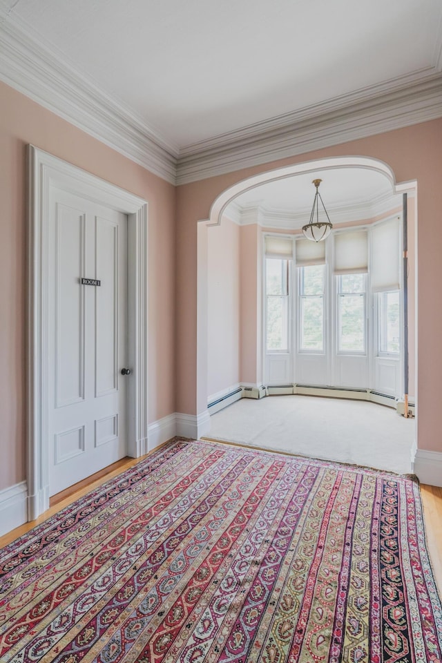 unfurnished room featuring a baseboard radiator, ornamental molding, and light wood-type flooring