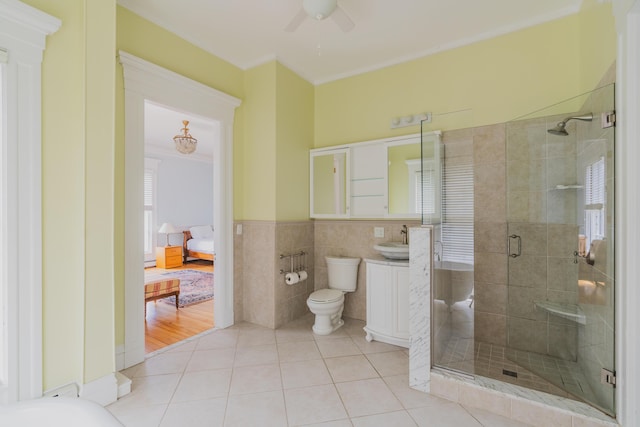 bathroom with toilet, tile walls, tile patterned floors, walk in shower, and ornamental molding