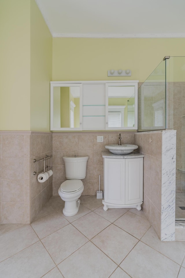 bathroom with toilet, tile patterned flooring, tile walls, and walk in shower