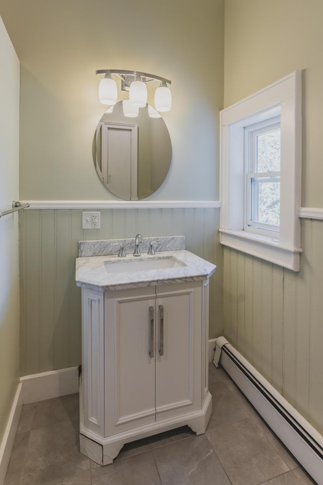 bathroom featuring vanity, baseboard heating, and tile patterned floors