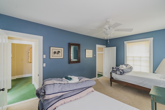 bedroom with ceiling fan, a baseboard heating unit, and light carpet