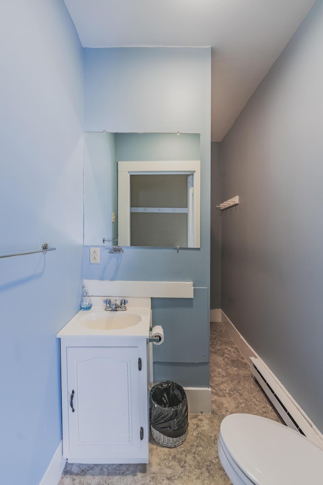 bathroom with toilet, vanity, and baseboard heating