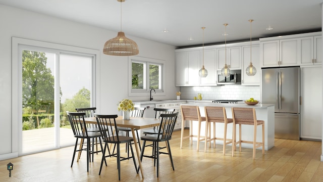 kitchen with white cabinetry, decorative light fixtures, stainless steel appliances, and a center island