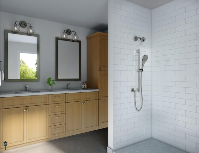 full bathroom with double vanity, tiled shower, and a sink