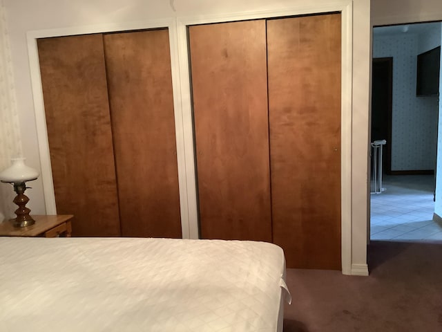 bedroom featuring multiple closets and carpet floors