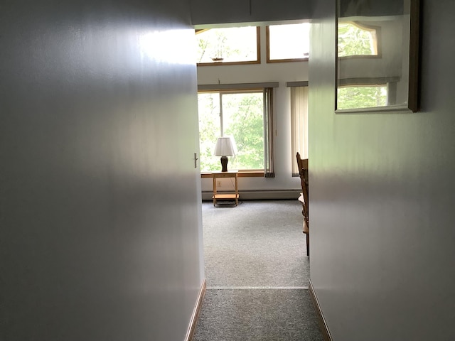 corridor with baseboard heating and carpet flooring