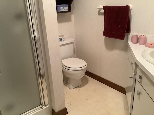 bathroom featuring toilet, a shower with door, and vanity