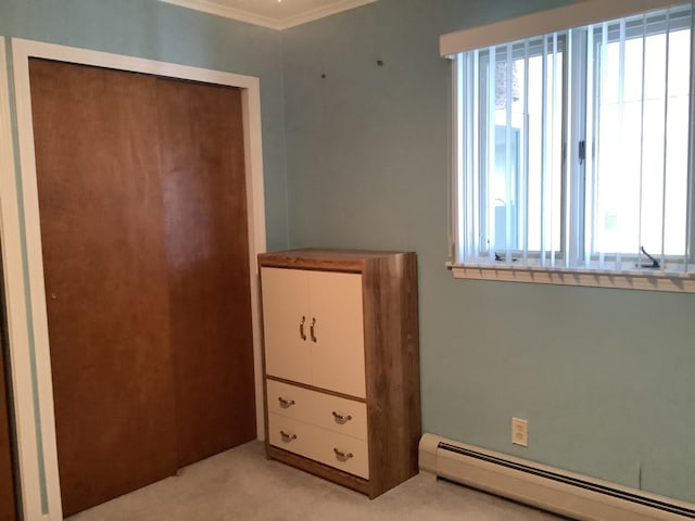 unfurnished bedroom featuring a closet, ornamental molding, light colored carpet, and a baseboard radiator