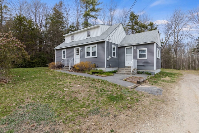 view of front of home with a shingled roof and a front yard