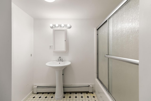 full bath with shower / bath combination with glass door, baseboard heating, tile patterned floors, and baseboards