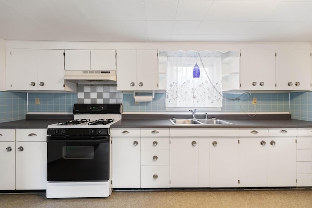 kitchen with dark countertops, white cabinetry, a sink, gas range, and under cabinet range hood