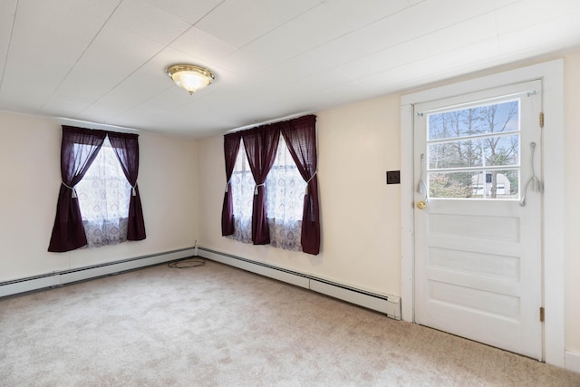 interior space featuring plenty of natural light, a baseboard heating unit, and carpet flooring