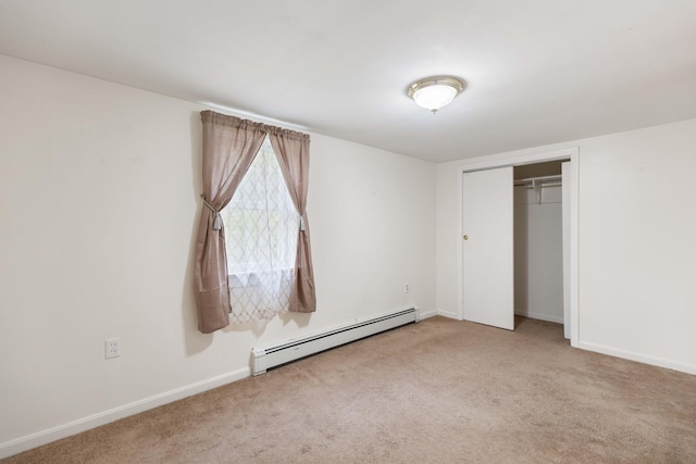unfurnished bedroom with a baseboard heating unit, carpet floors, and baseboards