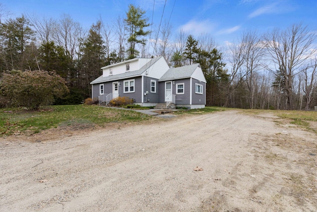 view of front of property with entry steps, roof with shingles, and driveway