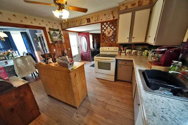 kitchen featuring electric range, sink, light hardwood / wood-style floors, and ceiling fan with notable chandelier