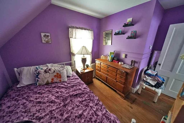 bedroom with wood-type flooring and lofted ceiling