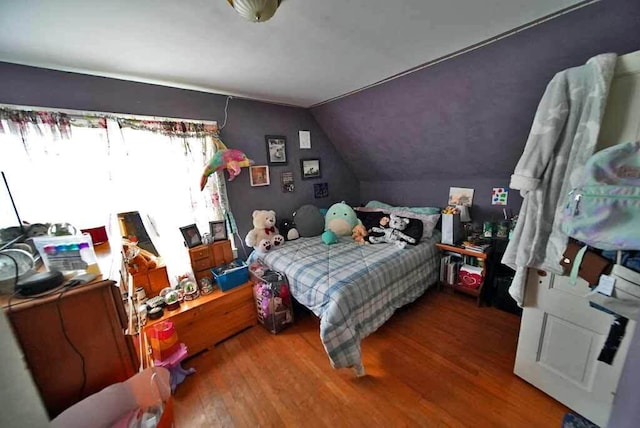 bedroom with hardwood / wood-style floors and vaulted ceiling