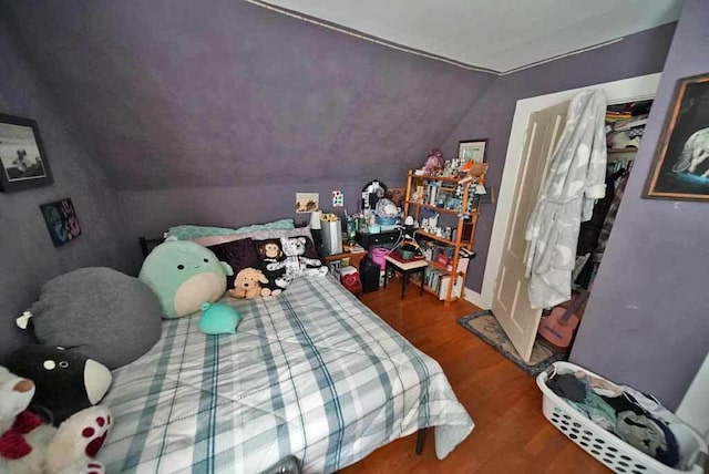 bedroom with wood-type flooring and lofted ceiling