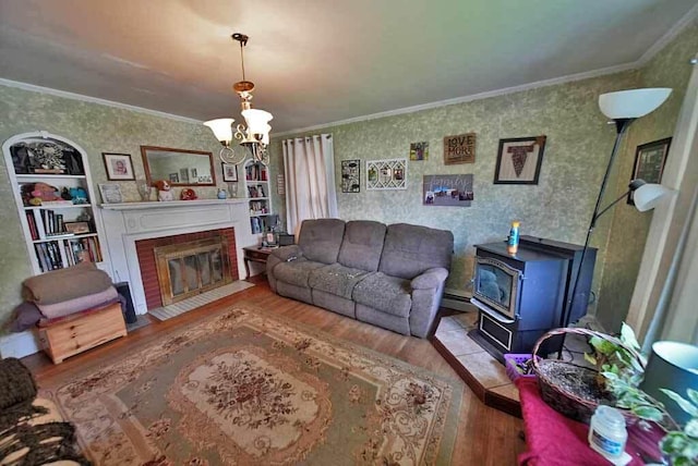 living room with built in features, wood-type flooring, ornamental molding, and an inviting chandelier