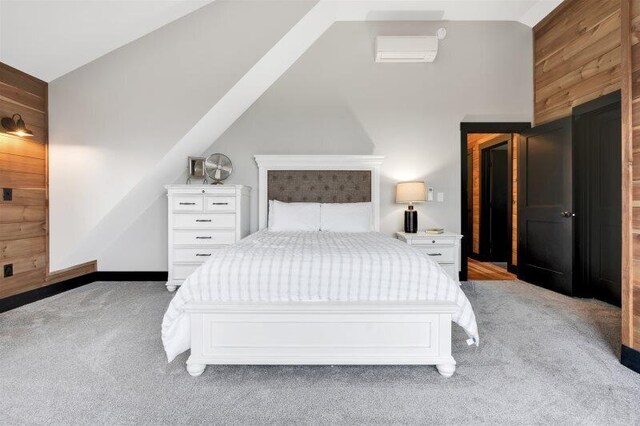 bedroom featuring wood walls, vaulted ceiling, and light colored carpet