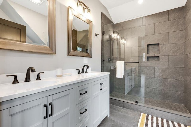 full bath with double vanity, a walk in shower, a sink, and tile patterned floors