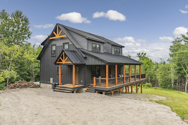 view of front of house with metal roof, roof with shingles, a porch, and a standing seam roof