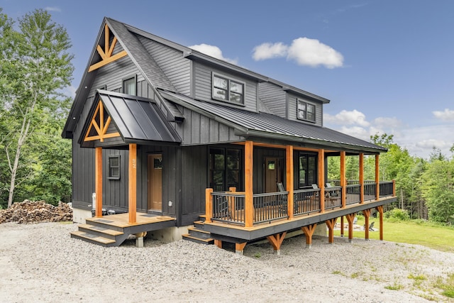 view of front of property featuring metal roof, a porch, a shingled roof, board and batten siding, and a standing seam roof