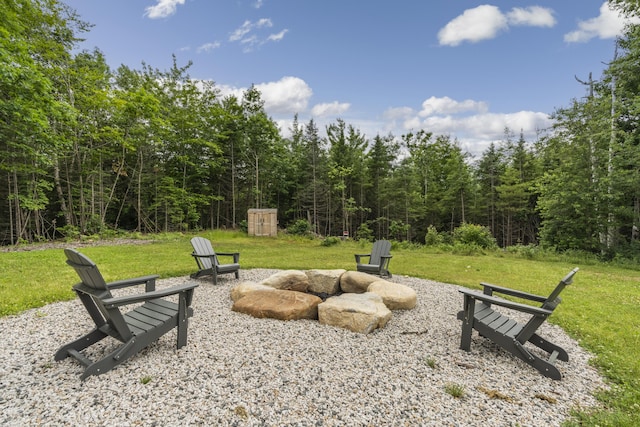 surrounding community featuring an outdoor fire pit and a lawn