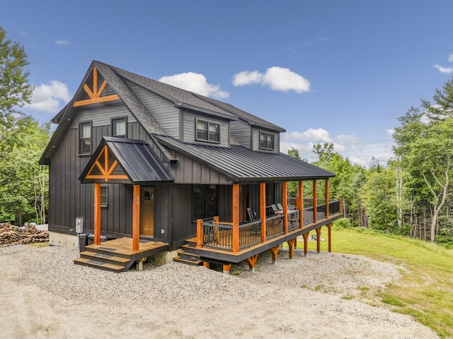 rear view of property featuring a shingled roof, a standing seam roof, metal roof, and board and batten siding