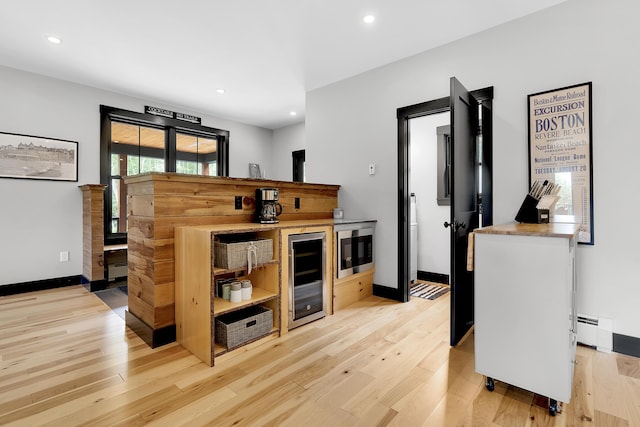 interior space with light wood-style flooring, baseboards, baseboard heating, and recessed lighting